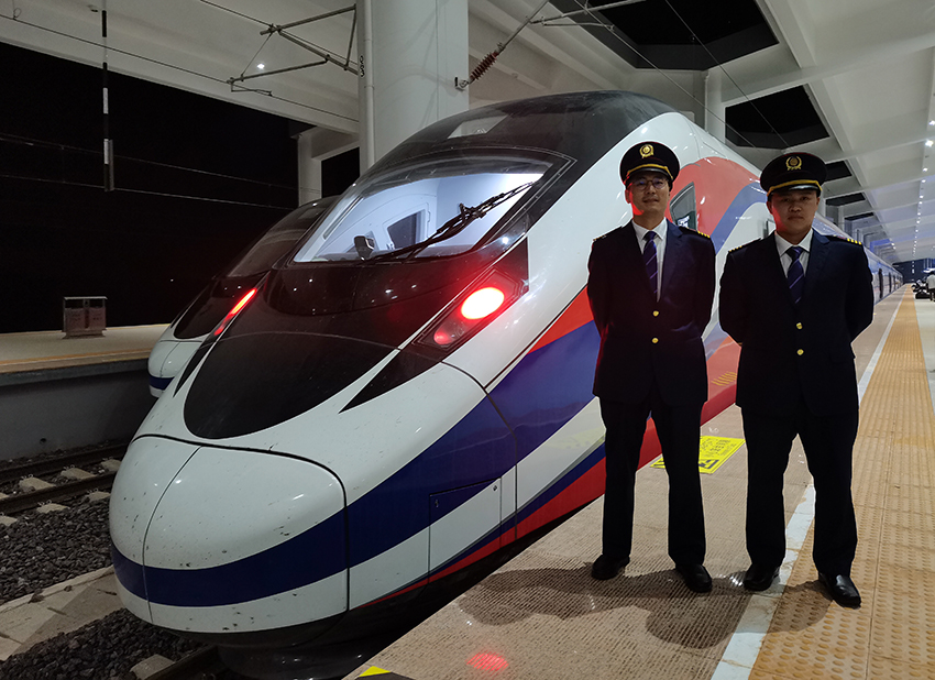 劉銀能（右一）與中國師父鄔俊鴻在動(dòng)車組前合影。受訪者供圖